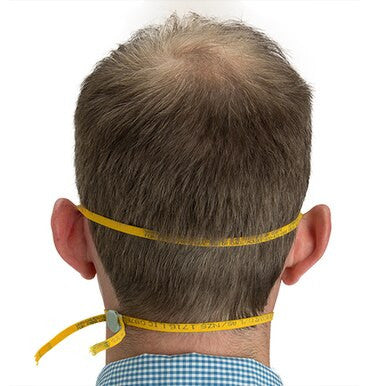A man with short brown hair in a blue checkered shirt measures his head circumference with a yellow tape—an essential step to ensure proper fit when using the Moldex N95 Disposable Waved Respirator 4600 (Box/10) by Moldex.