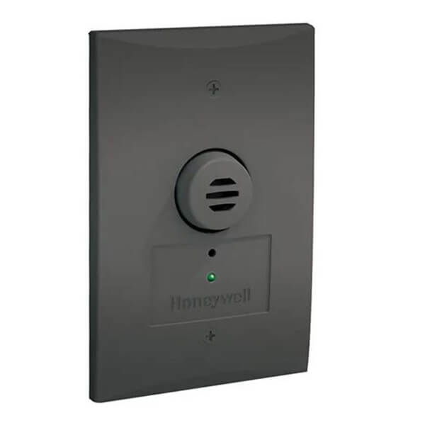 A black Vulcain Honeywell Analytics E3Point Remote Sensor with a round vented section and green indicator light, installed on a white wall as a gas detection device.