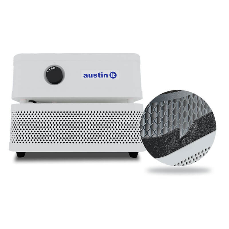 The Austin Air Systems "it" Machine C100 is a compact white air purifier with a control knob and perforated front panel, shown with an inset highlighting its internal filter mesh and layers for effective removal of airborne particles.