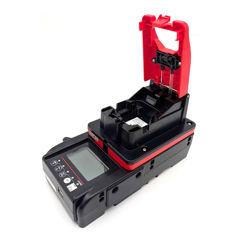 The RKI Instruments SDM-04 Calibration Station (Toxics) 81-SDM04SC-10_ features a black base, digital display, control buttons, and an open red clamp—ideal for fiber optic alignment and gas monitor calibration.