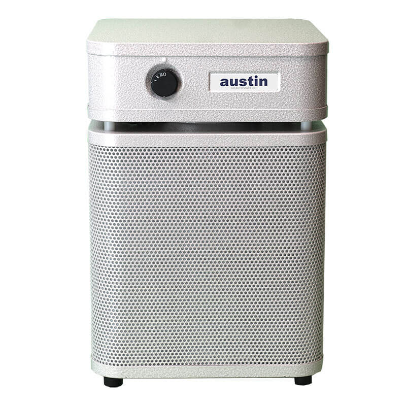 The Austin Air Systems HealthMate Junior Machine A200 is a white HEPA air purifier with a front dial, label, perforated metal grille on the lower section, and four legs—ideal for allergy relief.