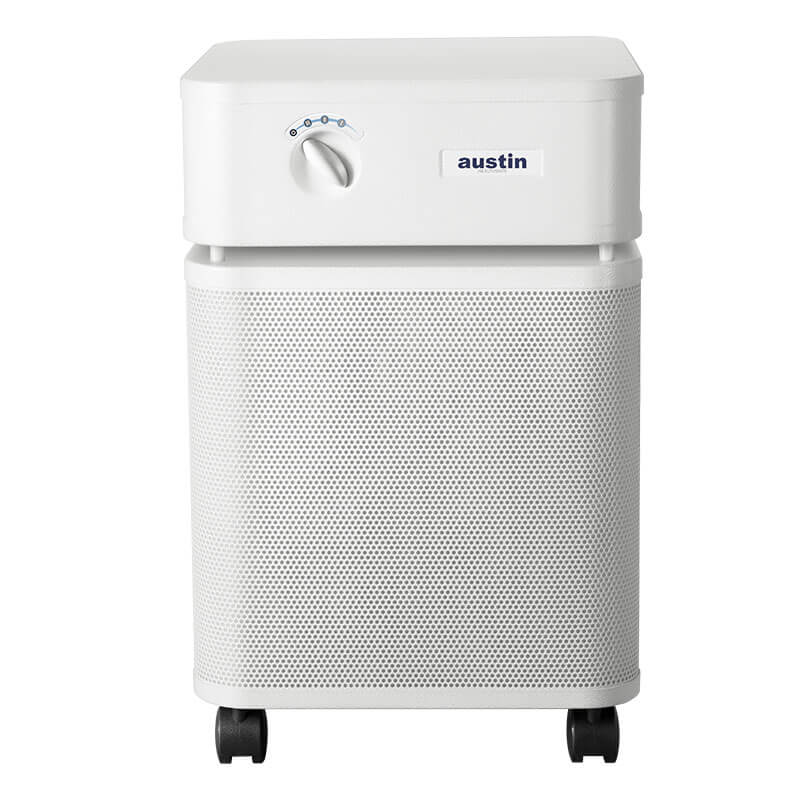 The Austin Air HealthMate Plus Machine B450 by Austin Air Systems is a white rectangular purifier with a rounded top, control knob, "austin" label, perforated lower section, four black casters, and medical-grade HEPA filtration for formaldehyde removal.