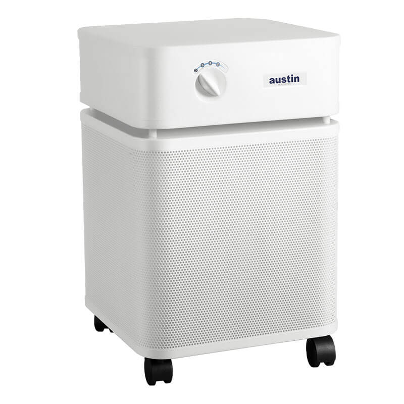The Austin Air Systems HealthMate Plus Machine B450 is a white, square air purifier with medical-grade HEPA filtration for formaldehyde removal, a front control dial, and four caster wheels for easy mobility.