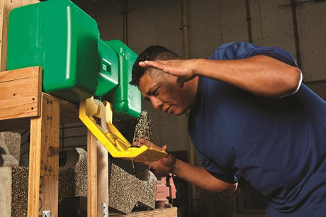 Man standing with his head above an eyewash station.