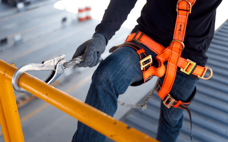 Construction worker use safety harness and safety line working at height at construction site.