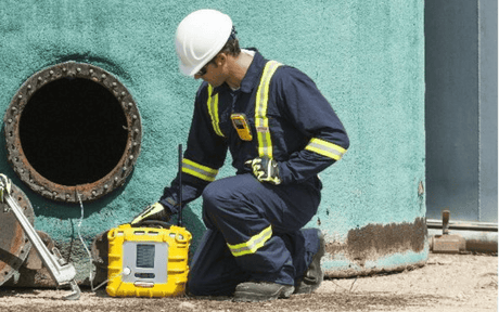 Worker testing gas outside of confined space entry.