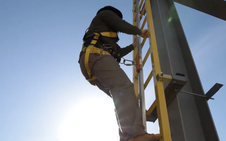 Man climbing tower ladder wearing FrenchCreek 800 Series Tower Climbing Harness from FrenchCreek Fall Safety.