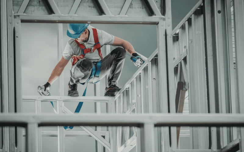 Person on a high-rise building construction site wearing safety gear.