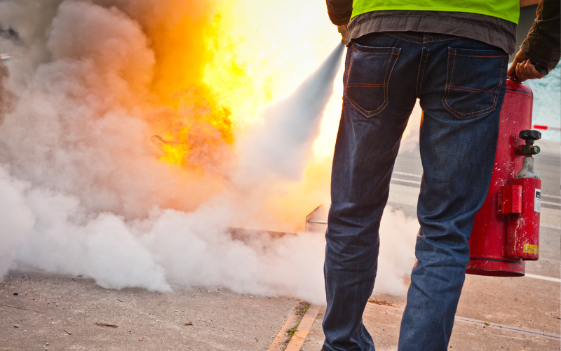 Person puts out fire with fire extinguisher.