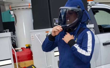 Worker adjusting Arc-rated hood/helmet.