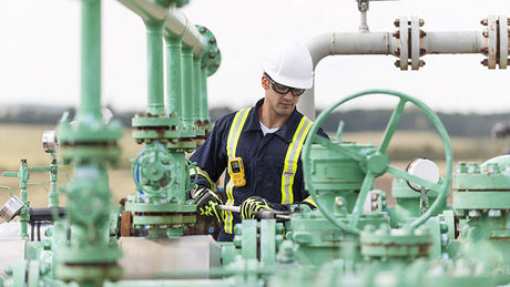 Worker wearing portable gas detector.