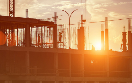 Constructions workers at a job site during sunset.