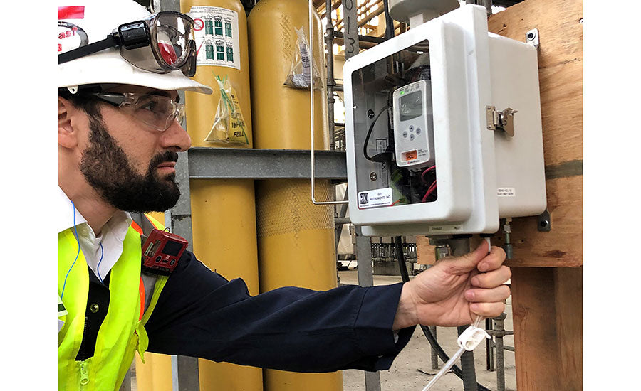 Worker wearing a portable gas detector.