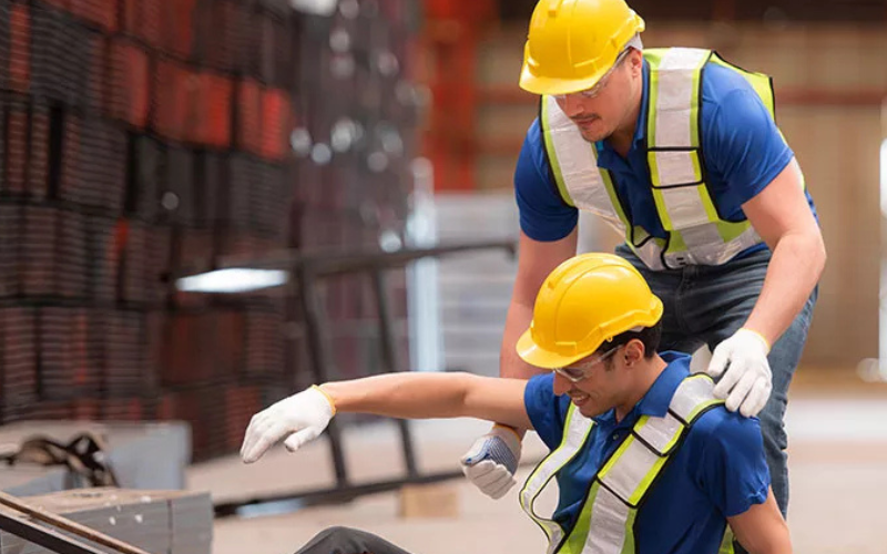 Worker helping a fallen worker up.