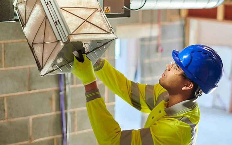 Worker working on dusty vent.