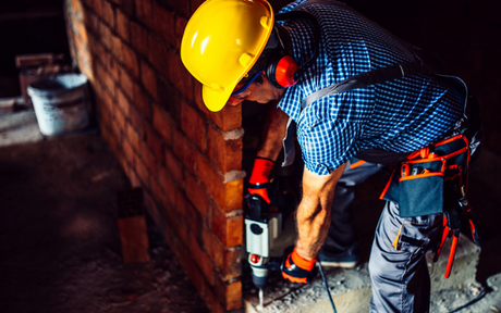 Construction worker wears earmuffs to prevent hearing loss.