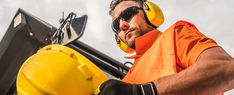 Worker wears earmuffs for hearing protection