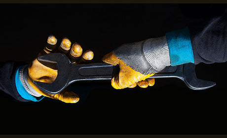 Worker wearing safety gloves while handling tools.