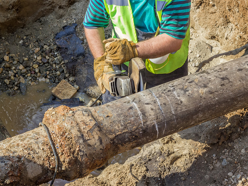 Worker wears safety gloves while working in trenches.