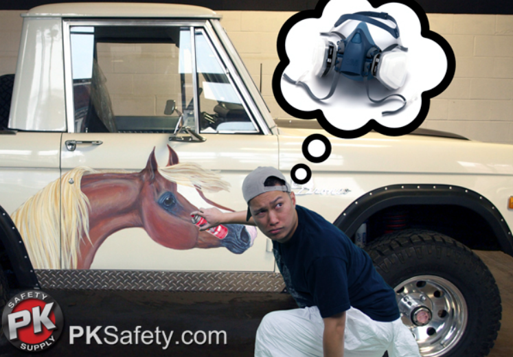 Guy squatting down while spray painting a horse on the side of a truck.