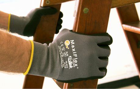 Person wearing MaxiFlex gloves while holding a ladder.