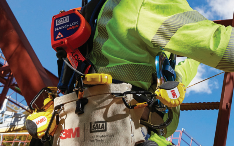 Worker at height with tools tethered.