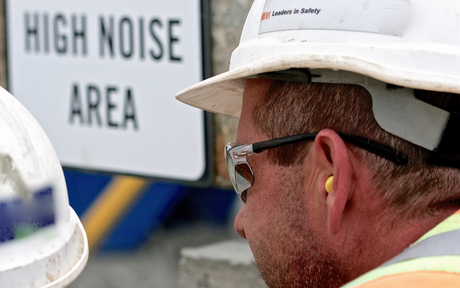 Worker wearing ear plugs in high noise area.