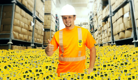 Man standing waist-high in yellow gas monitors in a warehouse giving a thumbs up.