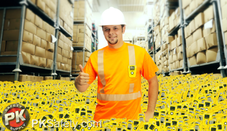 Many yellow gas monitors surrounding a worker waist-deep in a warehouse giving a thumbs up.