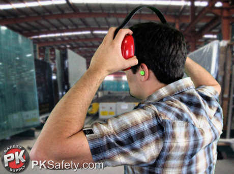Man puts ear muffs over his ear plugs.