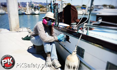 Person painting boat while wearing respirator.