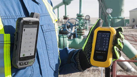 Worker holding gas detector at jobsite.