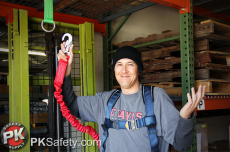 Man smiling while wearing harness and holding lanyard.