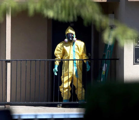 Person wearing yellow hazmat suit in building complex