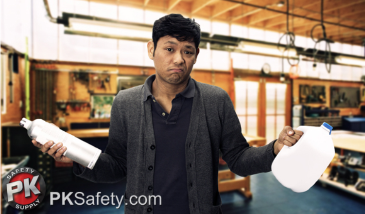 Man holds canister in on hand and gallon of liquid in the other. Workshop in background.