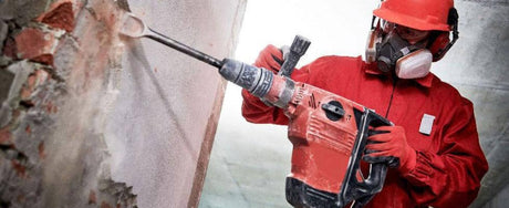 Worker drilling into a wall.