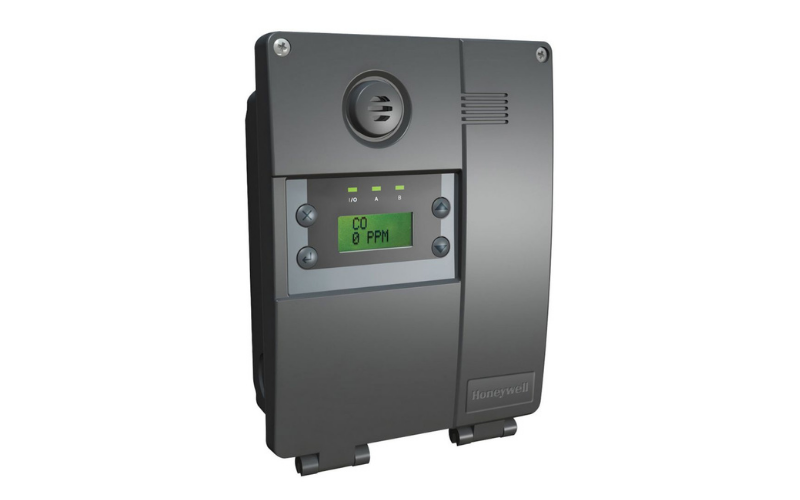 Gray Honeywell E3Point gas detection device with a digital screen displaying CO2. It features buttons and a vent, suggesting a wall-mounted control or monitoring unit.