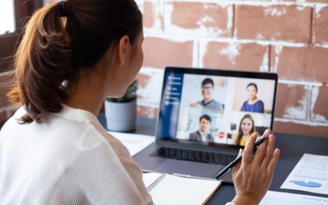 Worker telecommuting in a group video call.