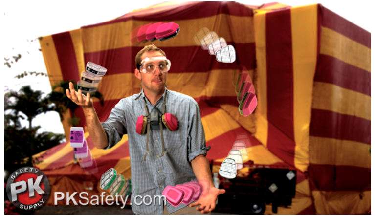 Man juggling respirator filters with building covered in tent behind him.