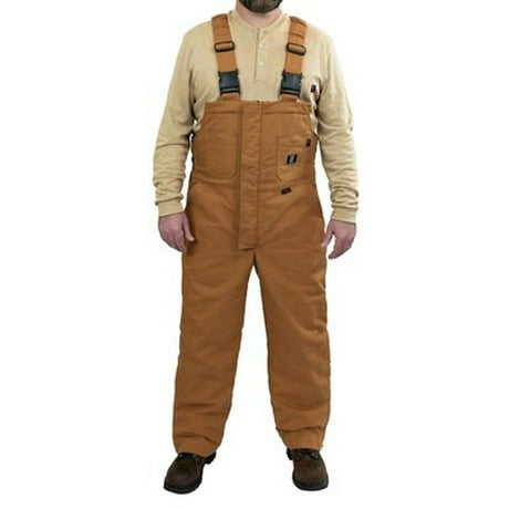 A person wearing tan insulated bib overalls and a beige long-sleeve shirt stands facing forward. The overalls feature front pockets and adjustable black straps. Brown shoes complete the outfit.