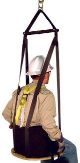 A person wearing a safety harness and hard hat is seated in a French Creek Deluxe Work Seat w/Comfort Seat Back 4151 from French Creek Production, within a suspended rigging system and secured by straps. Facing away from the camera, they are demonstrating fall protection equipment designed for working at heights.