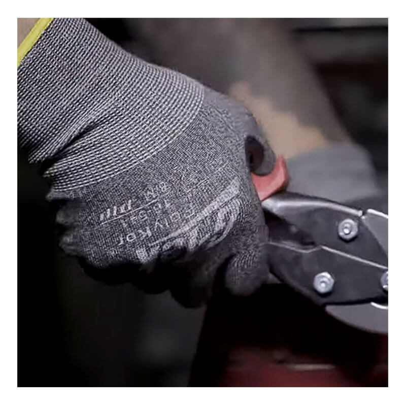 A person wearing PIP G-Tek PolyKor Blended Touchscreen Gloves (16-541) is gripping metal cutting snips, preparing to cut a piece of metal.