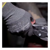 A person wearing PIP G-Tek PolyKor Blended Touchscreen Gloves (16-541) is gripping metal cutting snips, preparing to cut a piece of metal.