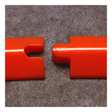 Close-up of two interlocking red plastic edges on a gray surface. One edge features a notch, and the other boasts a protruding piece, reminiscent of the UltraTech Spill Berm Low-Profile Model 2052's urethane design by UltraTech International, indicating they can be seamlessly connected.