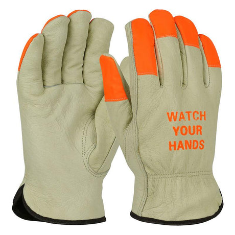 Introducing the PIP Top Grain Pigskin Leather Gloves—crafted from gray pigskin leather, these gloves feature bright orange Hi-Vis fingertips and cuffs for optimal visibility. The back of one glove prominently displays "WATCH YOUR HANDS" in matching orange, ensuring heightened safety and awareness at work.