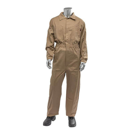 A gray mannequin stands upright wearing the PIP AR/FR Dual Certified Economy Coverall 9100-2000E by Protective Industrial Products, which is beige with long sleeves and a collar and comes with an ARC rating. The coverall includes a front zipper, pockets, and an elastic waistband. Black shoes complete the ensemble against a plain white background.