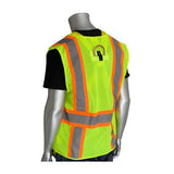 A mannequin is showcasing the PIP Yellow Mesh D-Ring Access Hi-Vis Vest 302-0600D-LY, a strikingly bright yellow vest from Protective Industrial Products, featuring reflective orange and gray stripes. When turned backward, it displays a black shirt under the safety wear.