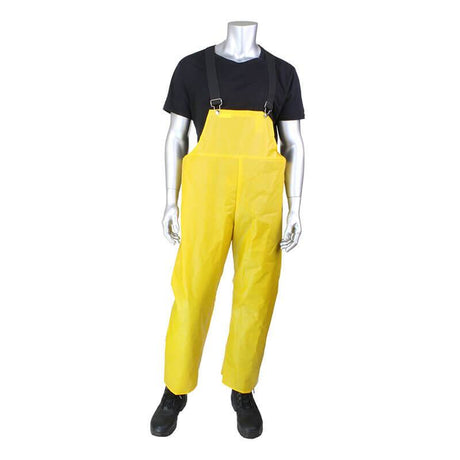 A silver mannequin is dressed in a black T-shirt, the PIP Boss TPU/Nylon Bib Overalls 201-510 in vibrant yellow, and sturdy black boots, all set against a white background. The overalls from PIP - Protective Industrial Products feature adjustable black straps, making them ideal for industrial plant maintenance.