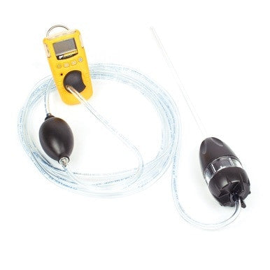 A BW Honeywell digital device in yellow is connected via transparent tubing to two black components resembling the BW Manual Aspirator Pump Kit with Probe GA-AS02. The setup features a long clear rod at one end, indicating its capability for collecting air samples or connecting with gas monitor sensors in scientific or medical equipment.