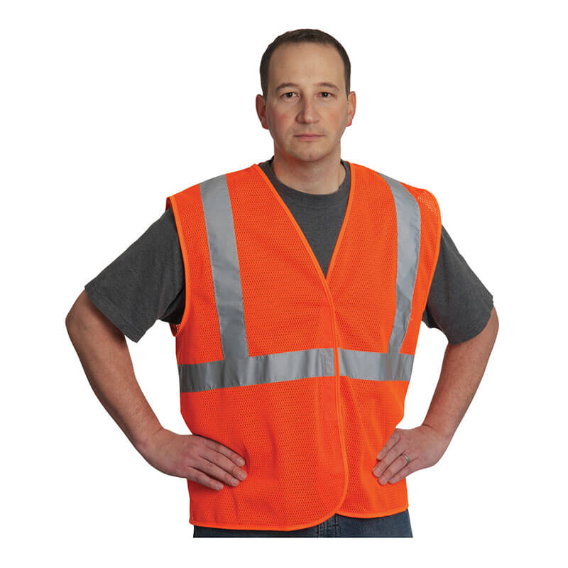 A man in a gray T-shirt wears a PIP Type R Class 2 Two-Tone Value Mesh Vest 302-MVG high visibility vest with reflective stripes, standing with hands on hips against a plain white background.